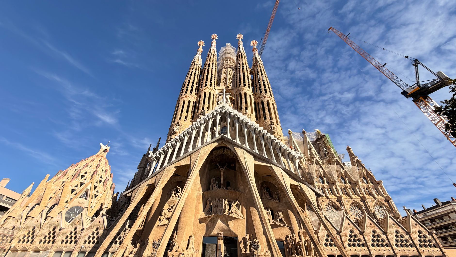 A stunning view of the iconic Sagrada Familia Cathedral in Barcelona, showcasing its intricate architecture against a clear blue sky.