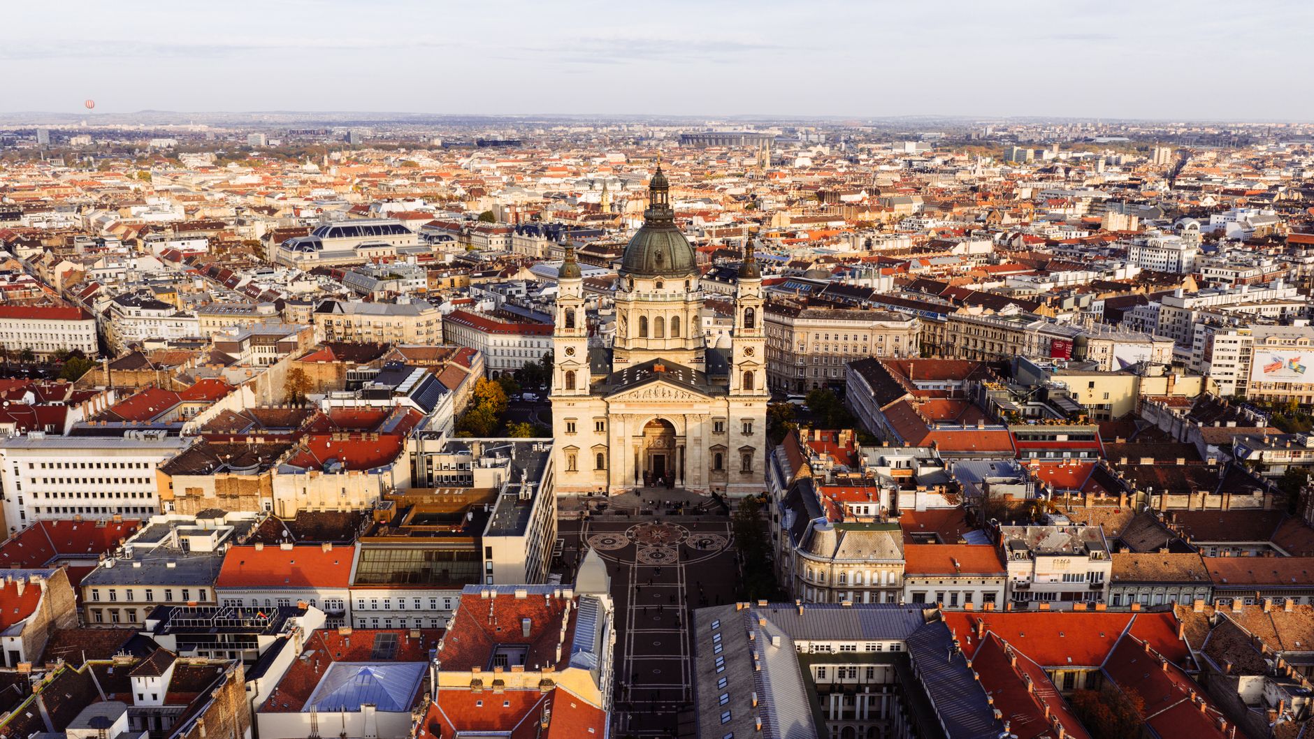 Explore a breathtaking aerial view of St. Stephen's Basilica in Budapest with its stunning architecture amid the city's landscape.