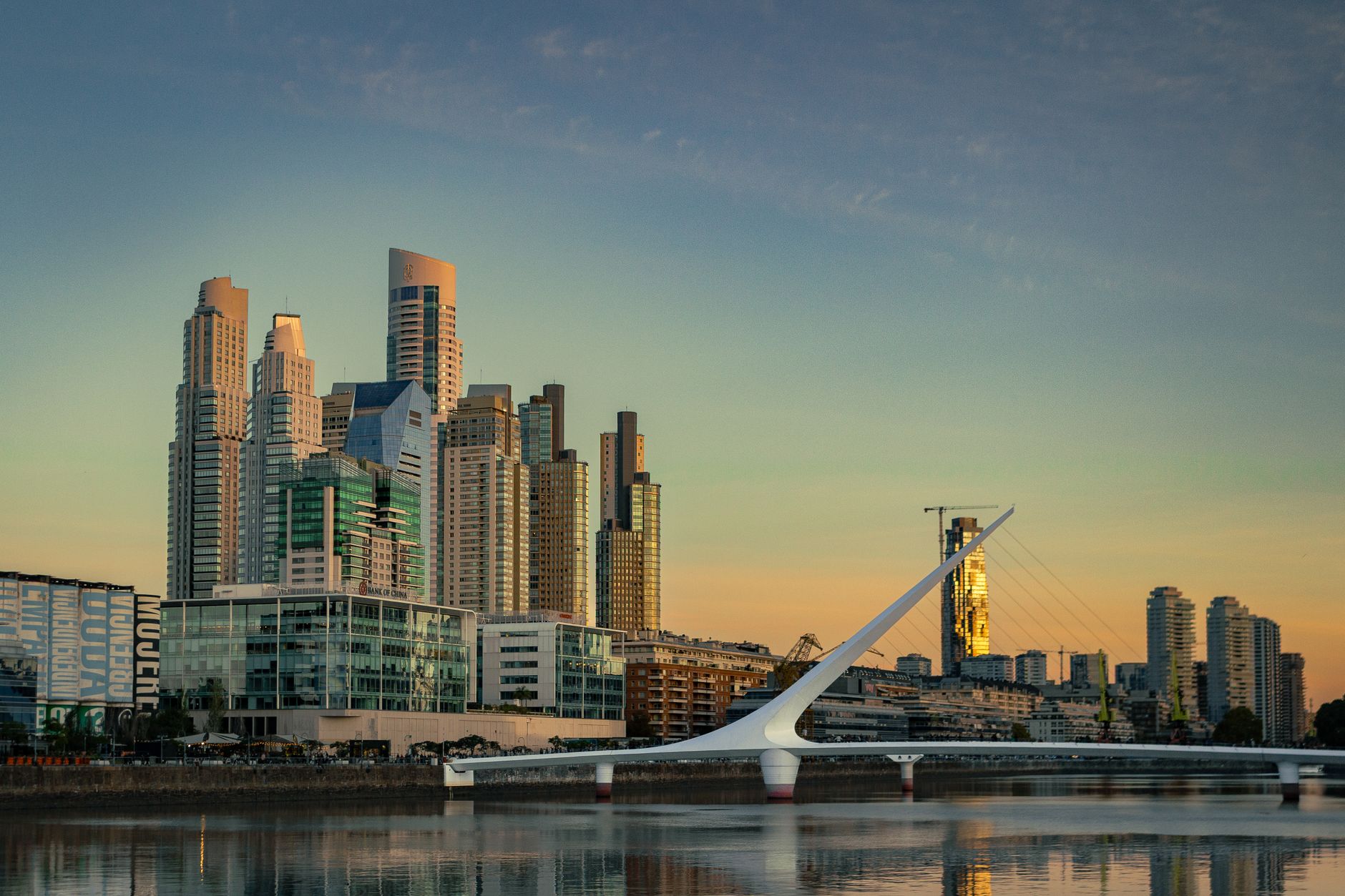 Stunning view of Puerto Madero's skyline during sunset with the iconic Puente de la Mujer bridge.
